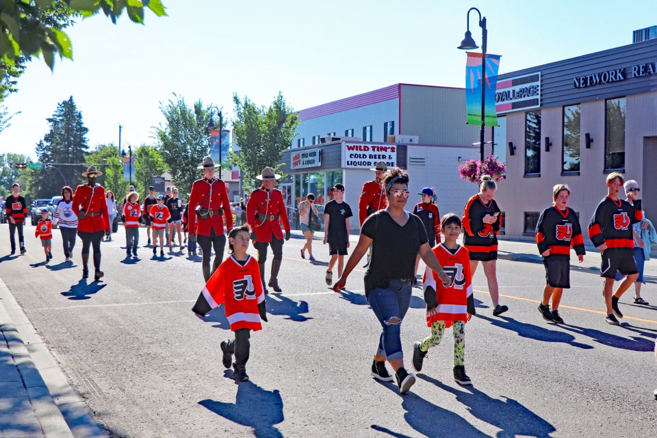 Young hockey players with the Innisfail Minor Hockey Association proudly march behind the Stanley Cup during a parade down Main Street on Aug. 8. The memorable day raised almost $11,000 that will benefit the future of minor hockey in the town. Johnnie Bachusky/MVP Staff