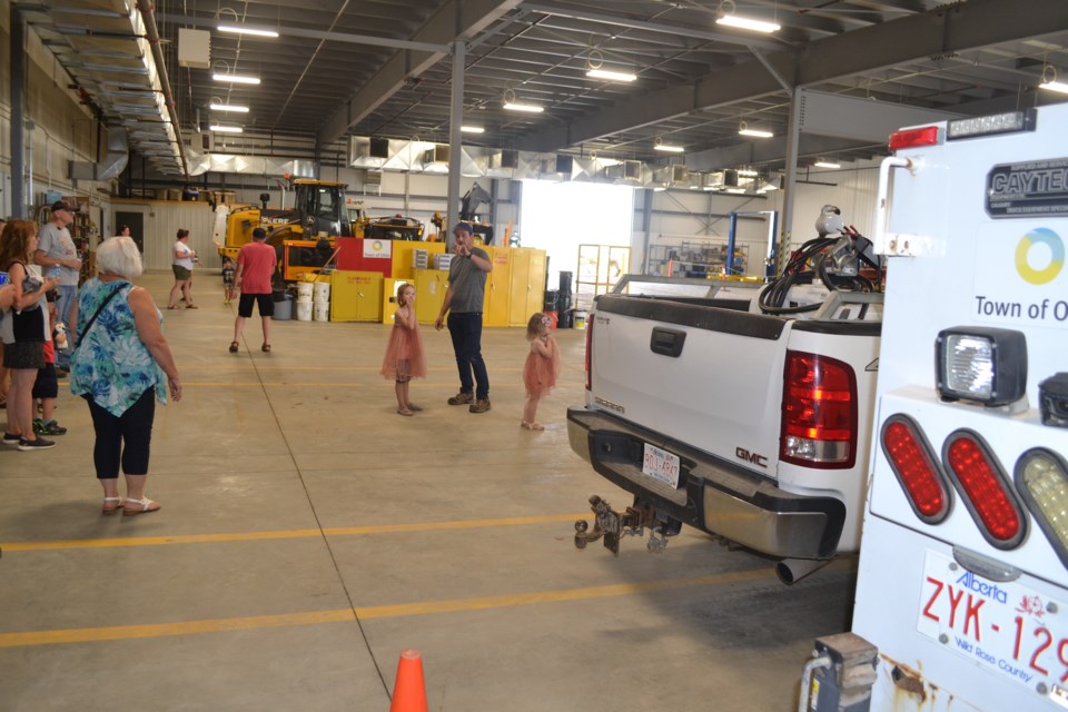 Facilities maintenance worker Carter Hammer gives a tour group a look at some of the vehicles parked in the shop/garage area of the new Town of Olds Operations Centre.