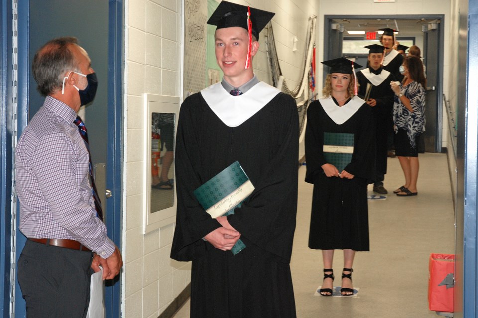 Physically distanced apart, graduates patiently waited their turns to be called up to walk across the stage with their diplomas already in hand. 
Simon Ducatel/MVP Staff