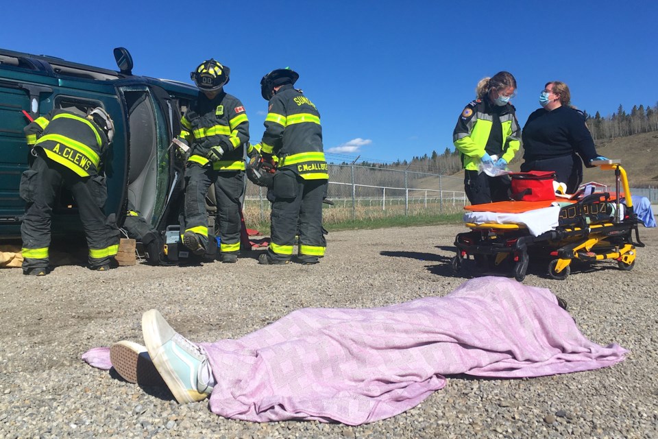 A Sundre High School drama club student plays the role of a victim declared deceased at the scene while emergency crews work diligently to extricate a patient from the wreck.
Simon Ducatel/MVP Staff