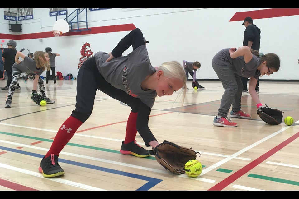 STOPPING GROUNDERS – Learning to get low and in front of a ground ball was among the skills practised by Sundre Minor Ball players on Saturday, April 22 at the Sundre High School gym during a softball clinic conducted by instructors Mike Weiss, from Sundre, and Mike Cowan, from Red Deer. Here, Reagan Rock, left, and Jayda Tooth get down low with their gloves on the ground. 
Simon Ducatel/MVP Staff