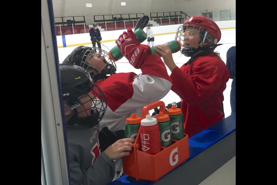 From left, Sawyer Suitor, Haidyn Mahan and Treyce Vanderzwan take a quick break to rehydrate before getting back to running drills on Thursday, Sept. 29 at the Sundre Arena. 
Simon Ducatel/MVP Staff