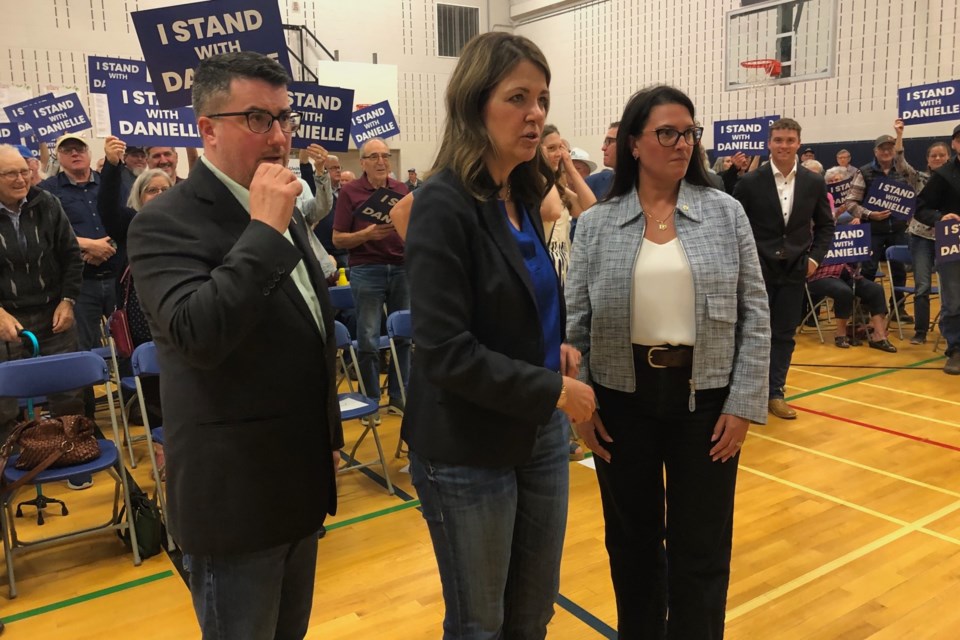 Nathan Cooper, Danielle Smith and Tara Sawyer pose for a photo at Saturday's meeting in Olds.