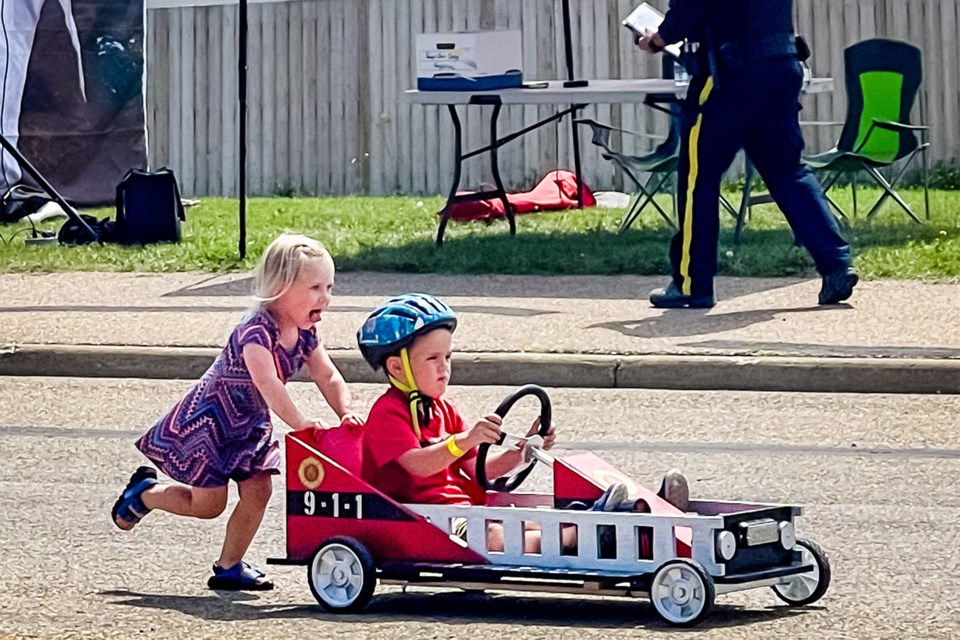 One of the 66 racers registered in the soap box derby gets some friendly assistance.