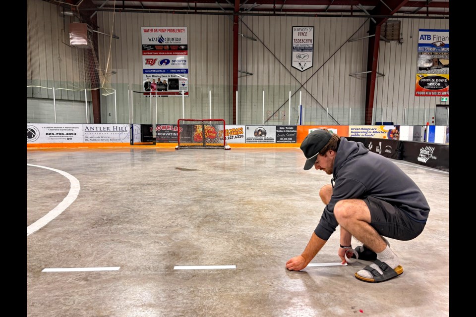 Jayce Pols, who has been with the Spring Fever tourney for the past 16 years as a player, volunteer and committee member, gets one of the playing areas ready for this year's event at the Innisfail Twin Arena on April 20. Johnnie Bachusky/MVP Staff