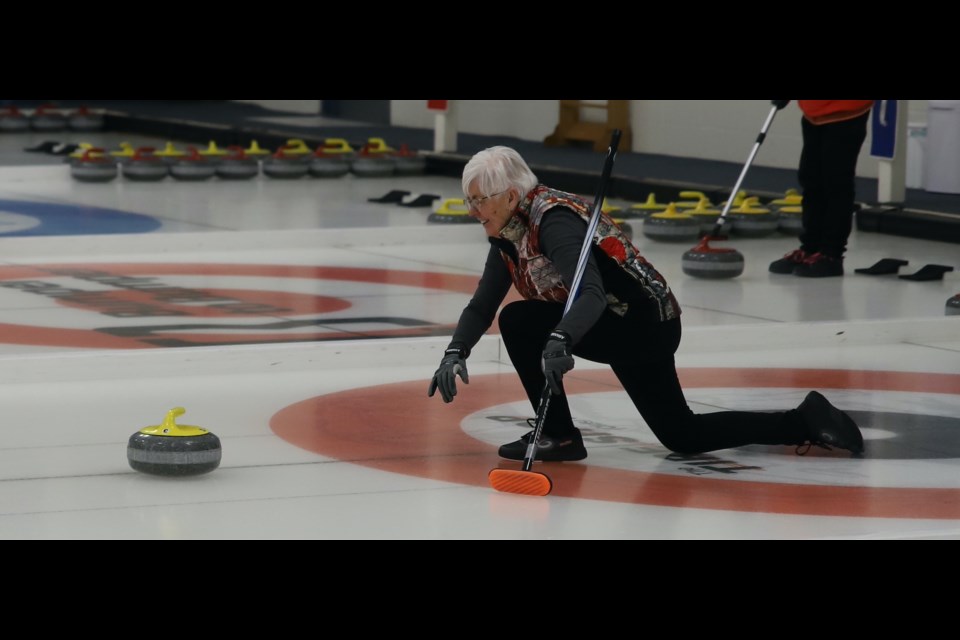 Peggy Kadey, a member of the Lang team, throws a rock during the seniors bonspiel Jan. 19 at the Olds Curling Club.