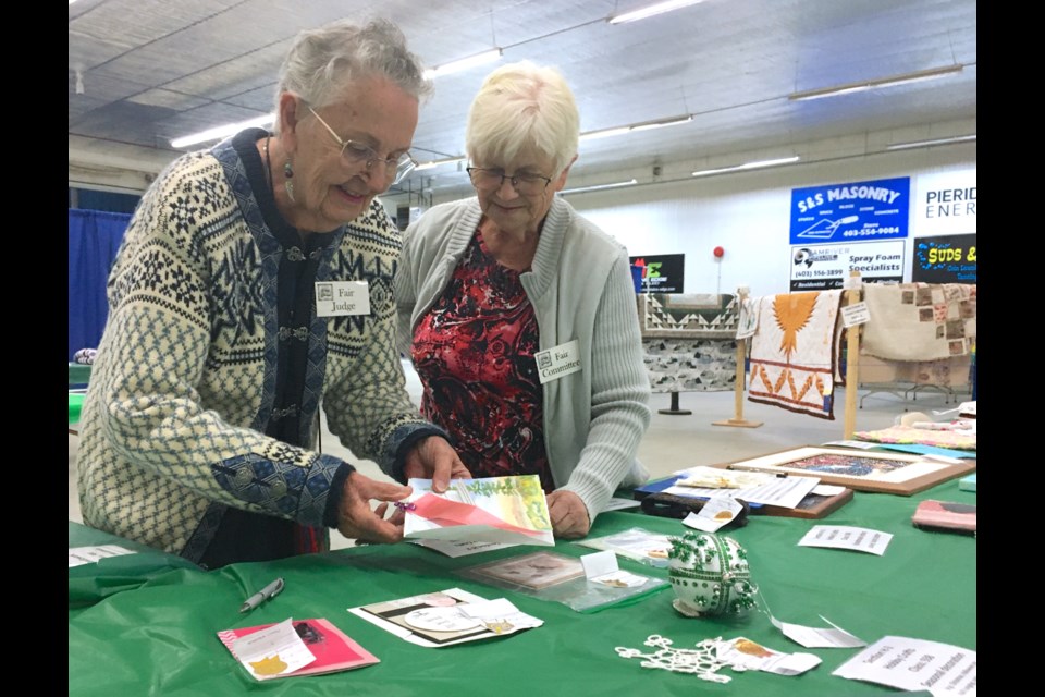 FAIR JUDGES – Sundre resident Annette Rose, fair judge, got a helping hand from Ila Johnston, who was recording the scores in the hobby crafts category. “It’s bigger this year than it was last year,” said Rose, who for the second year in a row returned to volunteer as a judge. 
Simon Ducatel/MVP Staff