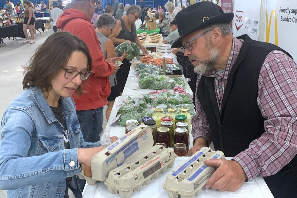 Melissa Esford, from Saskatoon, Sask., has a vacation spot near Sundre along the Red Deer River and was recently spending time in the area when she dropped by the Sundre Farmers’ Market where she picked up some eggs fresh from the farm. Ed Stahl, a farmer from the Olds area, has for years been a regular at the market and makes the trip every week accompanied by several helping hands including wife Kathrina. Simon Ducatel/MVP Staff
