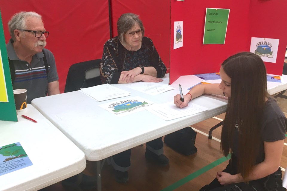 Hunter Coulis, who’s in Grade 9, was among numerous Sundre High School students who on Thursday, April 25 applied for a summer position at the non-profit Aspen Ranch Outdoor Education Centre, which had a couple of volunteers manning one of the many booths set up at the school’s gym during a community job fair. 
Simon Ducatel/MVP Staff