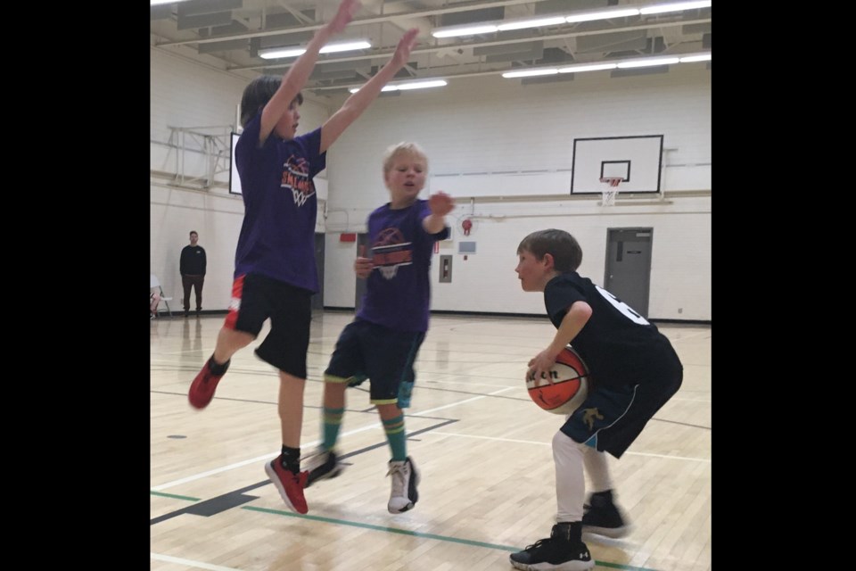 Drew Murphy looks to find an opening to shoot on Friday, March 22 at the Sundre Communtiy Centre as Finn Dumas and Atticus Pettie screen his attempt. They were playing in the Sundre Basketball Hoops program’s season windup game. 
Simon Ducatel/MVP Staff