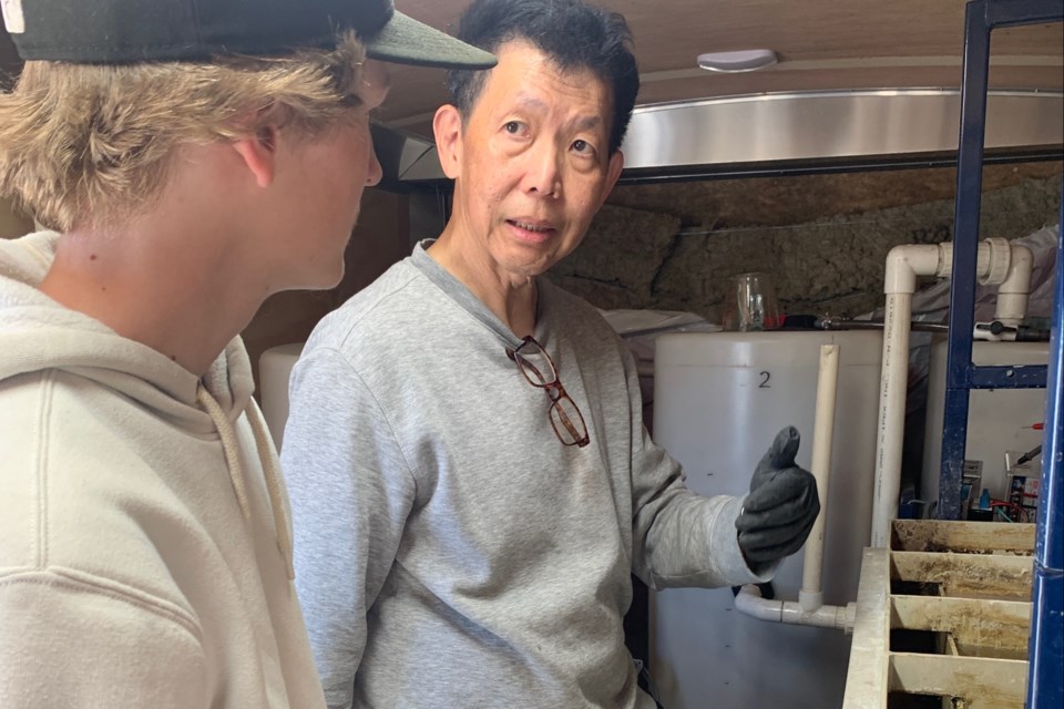 Gonzales Lee, Soneera Water’s vice-president of technical services and technology provider, explains the process of electroflocculation that treats wastewater using electricity without need for chemicals, to Aiden Davidson, a 16-year-old who is going into Grade 11 at Sundre High School with an interest in eventually pursuing post-secondary at SAIT to study software engineering and take a course to become an instrumentation and control technician. 
Simon Ducatel/MVP Staff