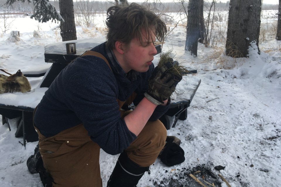 Christian White, one of last year’s Mountain Survivalist Competition contenders, gently blows on some kindling after sparking the dry fire starter to life. The competition’s third edition takes place Monday, Feb. 20 as part of the many activities lined up for Sundre Winterfest 2023. 
File photo/MVP Staff