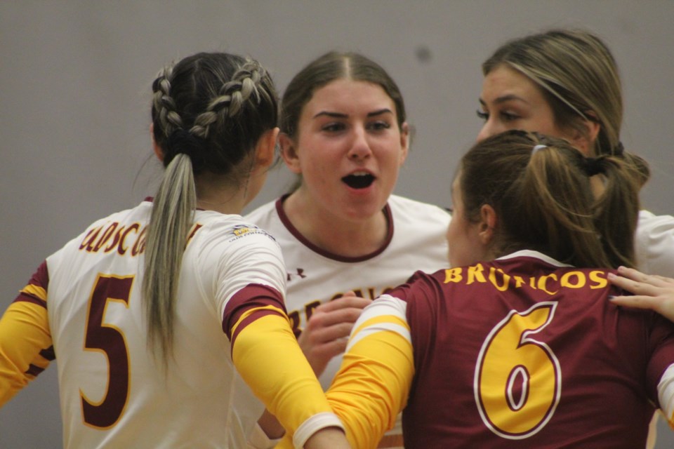 Tabitha Martin, centre, of the Olds College Broncos encourages her teammates as they play against the  Keyano College Huskies in ACAC women's volleyball.