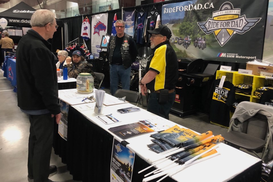 Ride For Dad members visit with a guest during last weekend's Didsbury Trade Show.