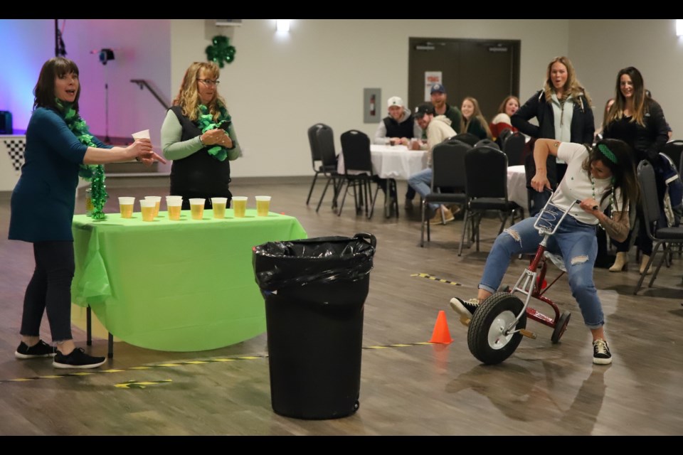 Jolene Cole finds it tough to round the corner and remain upright during the tricycle races at the Paterson Community Centre in Bowden on Friday, March 17. The races were part of the St. Patricks Day party, a fundraiser for Expanding Horizons which operates the hall.