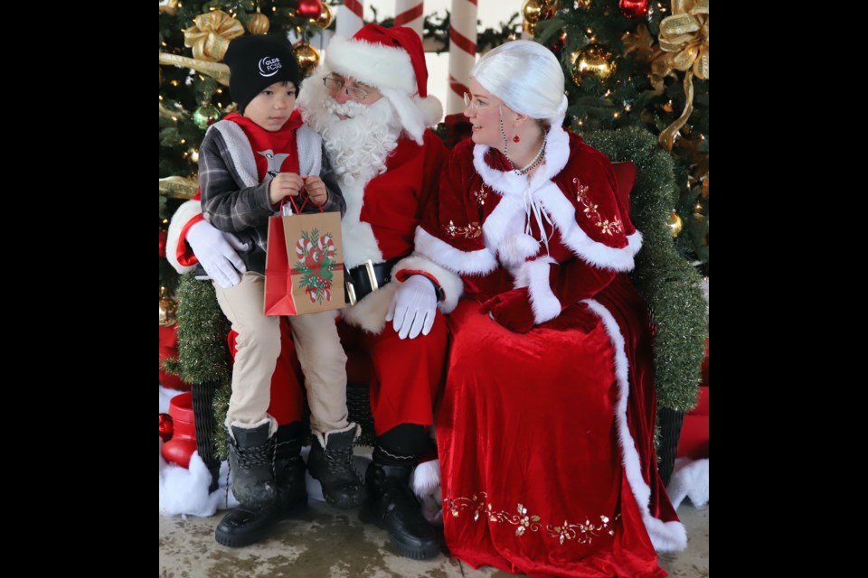 Israel Mossip, 6, visits with Santa and Mrs. Claus during the Olds Fashioned Christmas light-up event in Centennial Park Dec. 2.