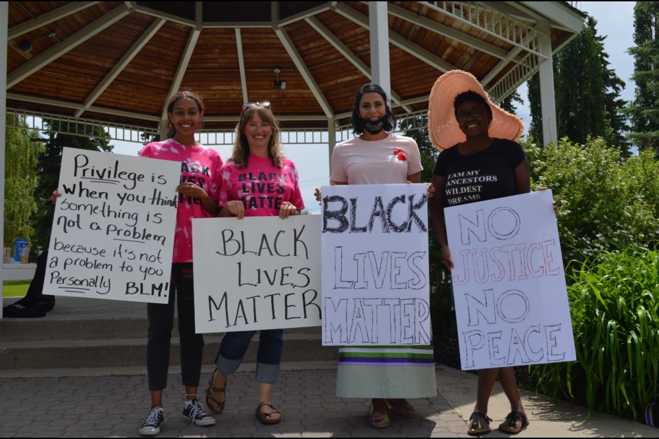 ANTI-RACISM CHAMPIONS - Tysha Saby (left to right), Sharon Saby, Sadie Khan and Roseline Eslinger hold signs during Saturday's Olds rally.