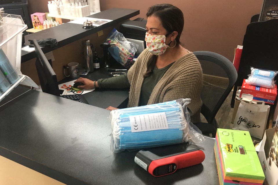 PREPARING TO REOPEN — Prepared with a personal reusable cloth mask as well as a compliment of disposable masks and a digital, non-contact infrared thermometer for clients, Kathy Augustowich, who owns Studio 104 hair salon in Sundre, checks emails on Monday, May 11 a few days before the planned reopening scheduled for Thursday, May 14. Other safety protocols she plans to implement include keeping the waiting lobby closed and only using every other styling chair to maintain physical distancing guidelines between patrons.  
Simon Ducatel/MVP Staff 