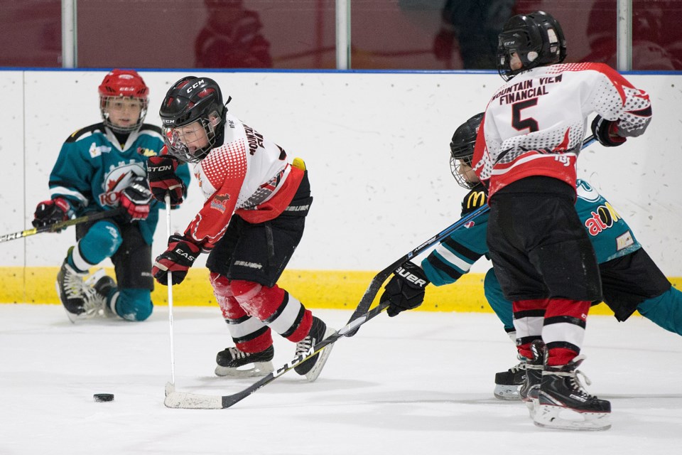 Sundre atom Husky Ryder Burwell skates the puck away from a Cochrane player with teammate Connor Mackenzie helping to watch his back on Friday, Dec. 6 during the local team's home tournament.
Noel West/MVP Staff