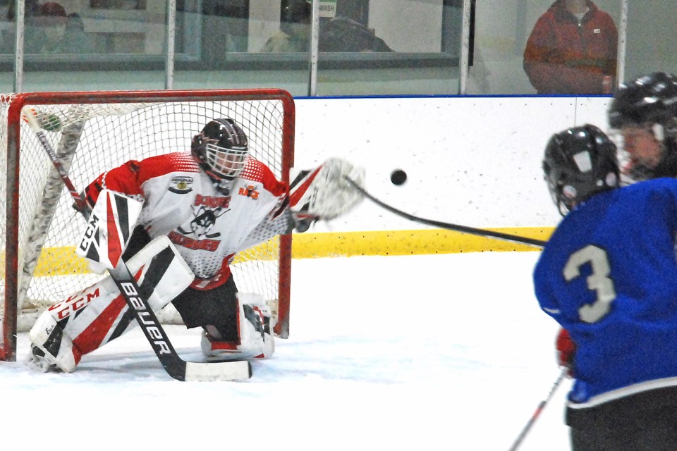 Sundre midget Huskies goaltender Jayke Juneau reaches out to glove a shot on Friday, 
Nov. 22 as the puck sails just slightly wide during the team’s Central Alberta Hockey League regular season opener on home ice against the Delburne Outlaws, who won 4-1. 
Simon Ducatel/MVP Staff