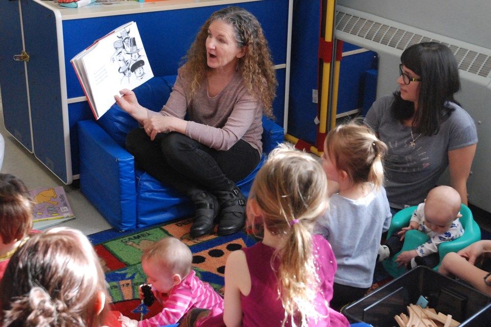 Accompanied by Joleen Fluet, right, Sundre's Parent Link former facilitator, Karen Tubb, library manager, reads a book called The Story of Ferdinand, by Munro Leaf, on Wednesday, Feb. 12 to a group of children during the final day of Parent Link programming in Sundre. 
Simon Ducatel/MVP Staff