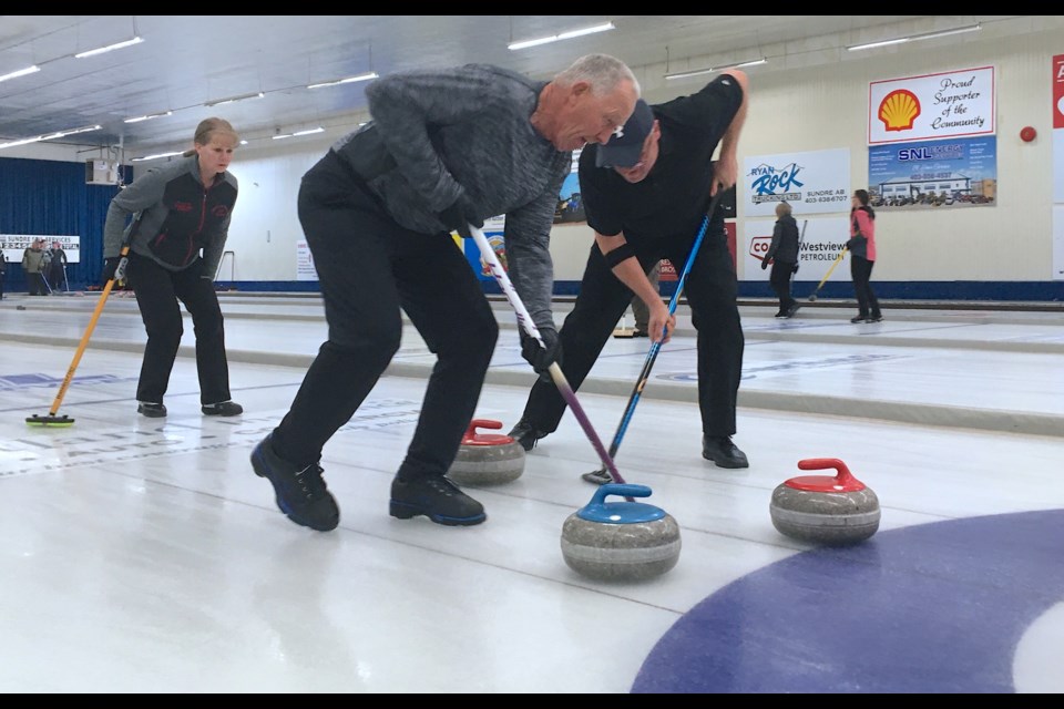 Gloria Anderson, from Eagle Hill, urges on sweepers Gerry Schalin, left, and Doug Reid. 
Simon Ducatel/MVP Staff