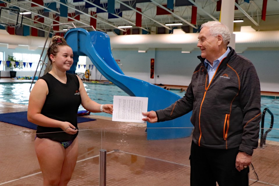 Gavin Bates hands Sarah Gette, Innisfail's 2020 winner of the Bates Wardle Award, a copy of his presentation on Oct. 19 at the Innisfail Aquatic Centre. Johnnie Bachusky/MVP Staff