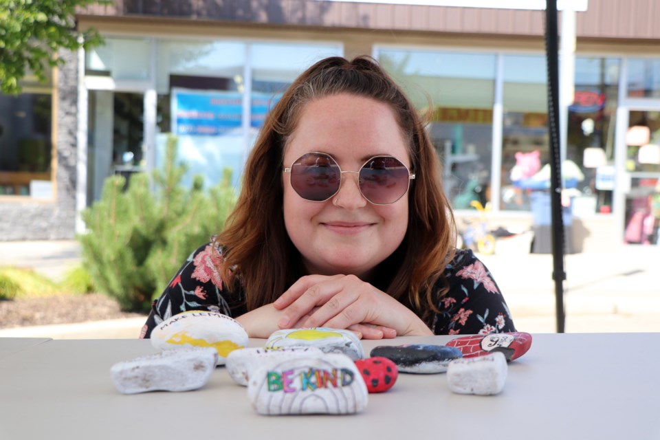 Lindsey Budd, assistant manager of the Innisfail Public Library, with kindness rocks at the launch of the new Kindness Rocks Garden initiative at the Market on Main on Aug. 18. She will be at the Market on Main every Tuesday until Sept. 8 to promote the initiative.  Johnnie Bachusky/MVP Staff