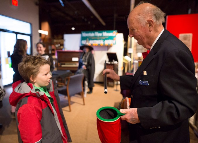 Nathanael Borg, left, helps Richard Wray with a magic trick at the Mountain View Museum.