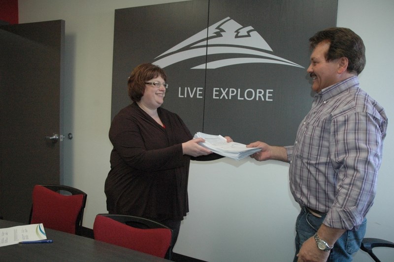 Rick Scown presents a petition to interim CAO Wanda Watson Neufeld last Friday which is signed by east side Sundre residents opposed to what they call the high cost of the