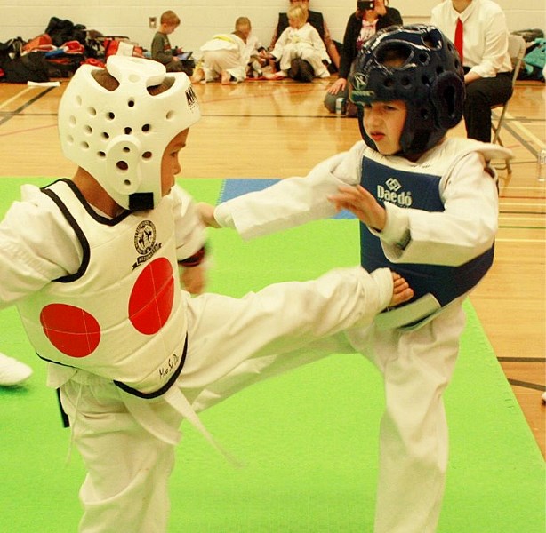 Four-year-old Brenden Johnson (left) kicks a blow at an oppoent during action at the Sundre tourney on Oct. 27.