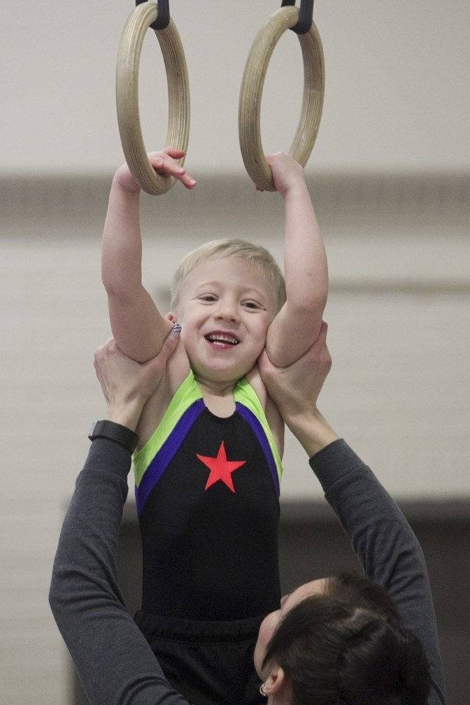REACHING FOR THE STARS ó Rylan Johnston gets some help on the rings during the 15th annual Sundre Gymnastics Meet at the Sundre Community Centre on March 18.,
