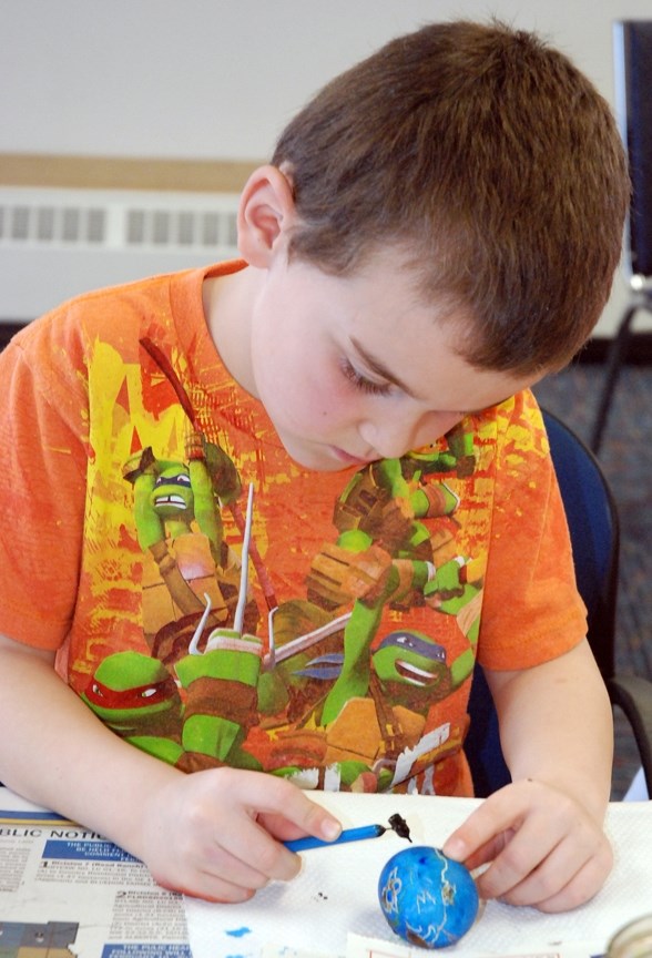CAREFULLY COLOURING EASTER EGGS ó Ricky Winsor, 6, was at the Sundre Municipal Library on Wednesday, March 16 with his cousin Hunter Vennard, 6, from Castlegar, B.C., and