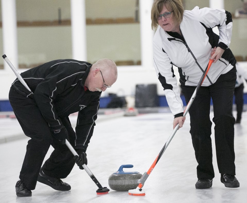 Curling season winds up with open bonspiel ó Robin Boyd, left, and Laurie Coopersmith sweep a rock during the local curling club&#8217;s annual open bonspiel in Sundre on