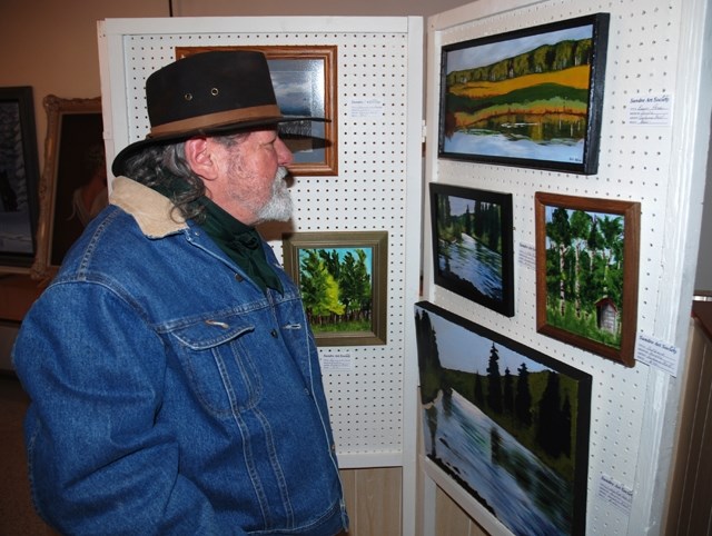 Paul Blondin, from Sundre, peruses the wide variety of paintings large and small during the Sundre Art Society&#8217;s 41st annual Art Show and Sale held recently at the West 