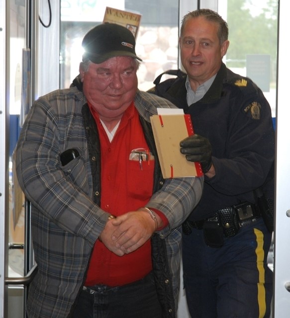 JAIL AND BAIL — The Sundre RCMP detachment&#8217;s Sgt. Jim Lank hauls in Connie Anderson last Thursday after &#8220;arrresting&#8221; him for cheering too loud at a