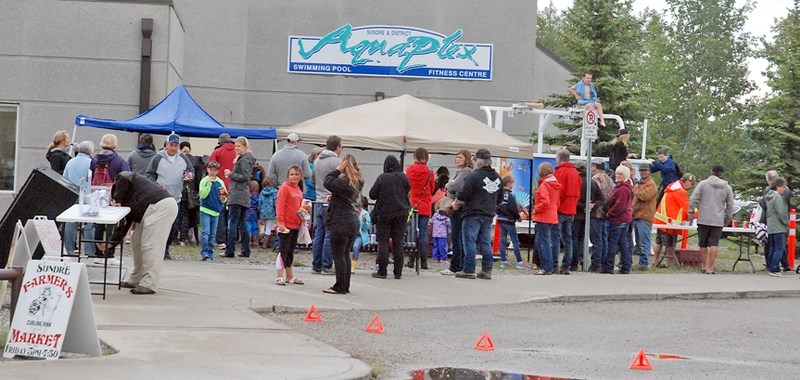 Judy Chrest, a Sundre resident of 45 years, buys a hotdog served up by aquatic society board member Bob Hillock, who is also a Sundre resident.,