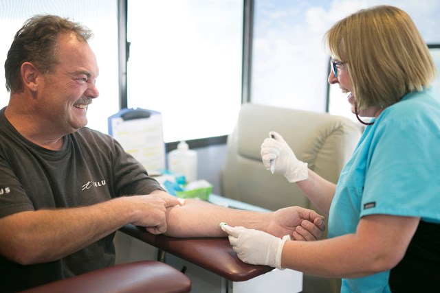Phlebotomist Joanne Skibsted shares on Sept. 16 a moment with Bruce Dunn after drawing a vial of blood during the Man Van&#8217;s stop in Sundre at the local ATB branch,