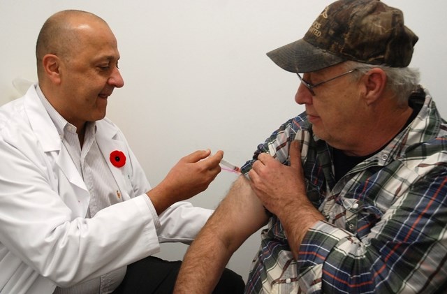 Mac Ghobrial, Sundre&#8217;s newest pharmacist, administers a flu shot to Dave Margareeth, who lives south of town. &#8220;Healthy Albertans are productive Albertans,&#8221;
