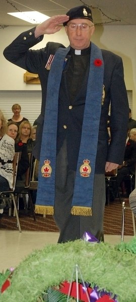 Sundre Legion Branch 223&#8217;s Comrade Chaplain Tim Kirby salutes after laying a wreath at the annual service at the legion&#8217;s hall. During his address to the packed