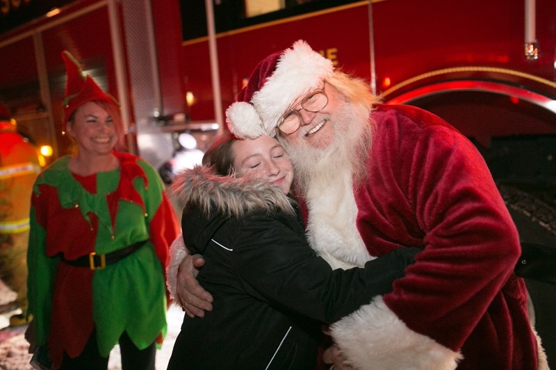 Santa Claus gets a hug after arriving at the Sundre Community Centre in a fire truck during Sundown in Sundre on Dec. 2.,