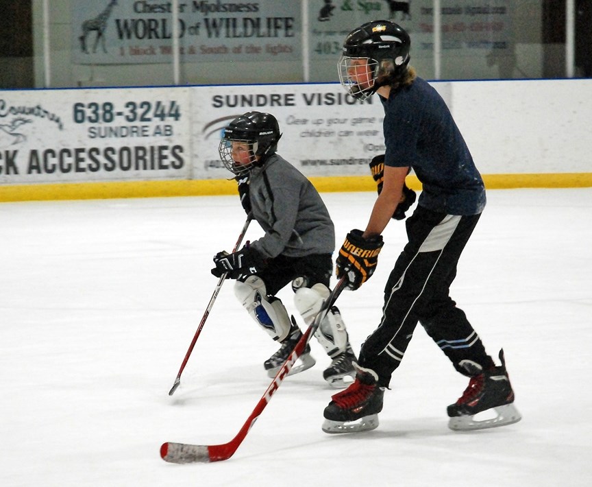Andrew Reicker, left, and Ethan Simpson had some fun with about a dozen other youths on Dec. 28 at the Sundre Arena during the facility&#8217;s sticks and pucks time slot,