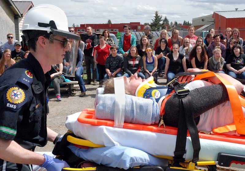 Sundre High School Drama club student Kayleigh Wolfe gets hauled away on a stretcher by Caleb Ould, EMT, during a staged fatal collision at the school on Friday.