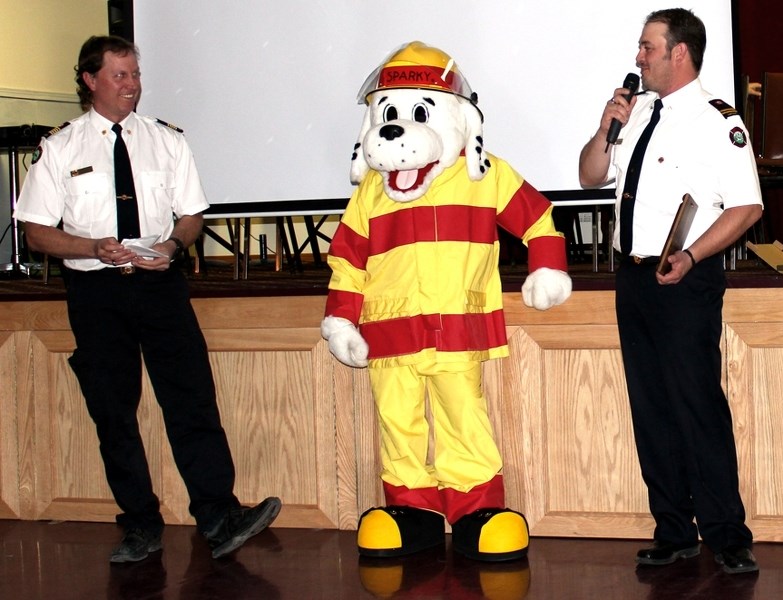 Dave Bennett, right, shares a few words after being presented with a 20-year service award from Chief Marty Butts during the Fireman&#8217;s Ball held towards the end of