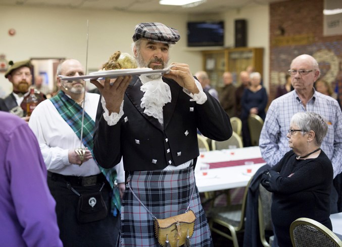 Jamie Moffat carries in the haggis.