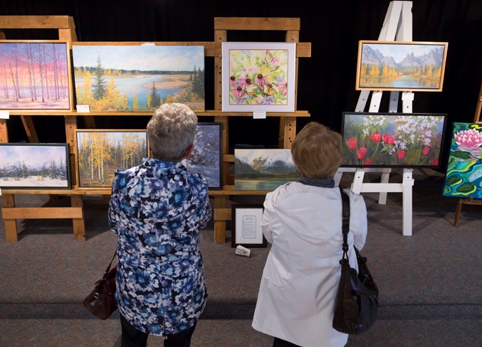 Terry Nelson, left, and Sheila Shea browse through the artwork on display.