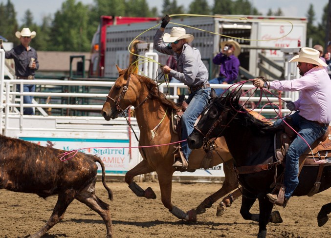  Roland McFadden and Devin Wigemyr chase down a steer during the team roping section.
