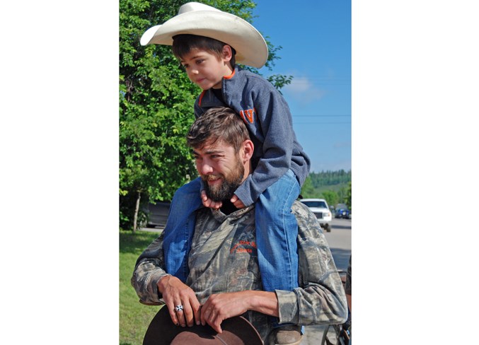  Dad Kris McLeod carries five-year-old son Wyatt on his shoulders as they seek out a spot to watch the parade.