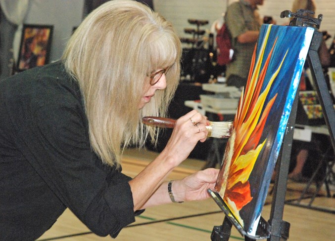  Rhonda van Vlaanderen, from the James River Bridge area, paints a sunflower during the live competition. Her piece later went on to be voted as people's choice.