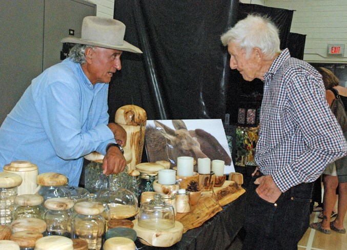  Local artisan Ray Coté, left, chats with Alec Macklin, who came out with wife Anne from the Eagle Valley area.